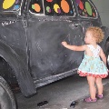 Child drawing on chalk-covered Beetle.
